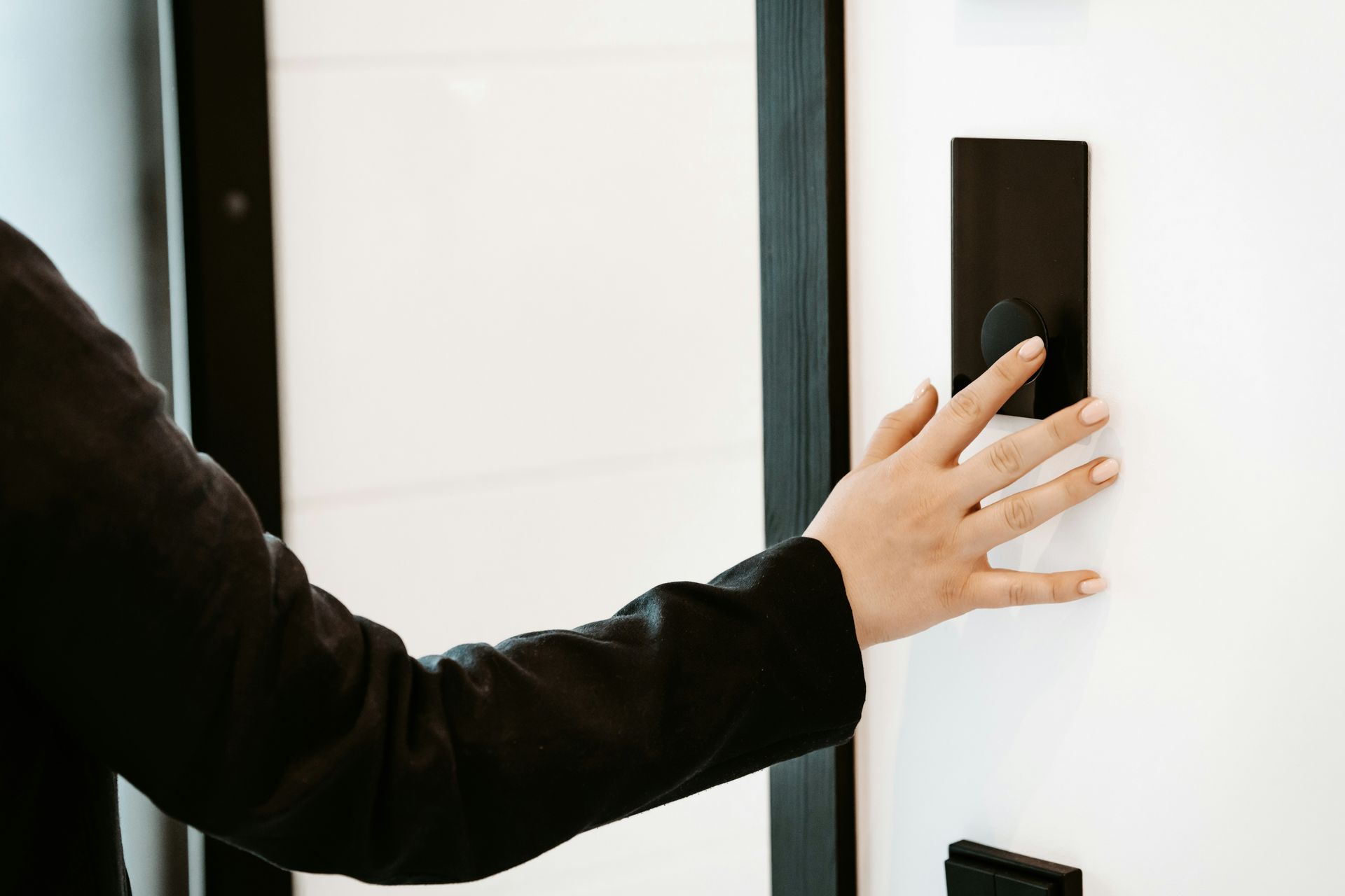 a person is pressing a button on a white wall